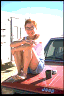 A young person sitting on a truck.