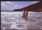 [A couple on vacation from France wade in the surf.]